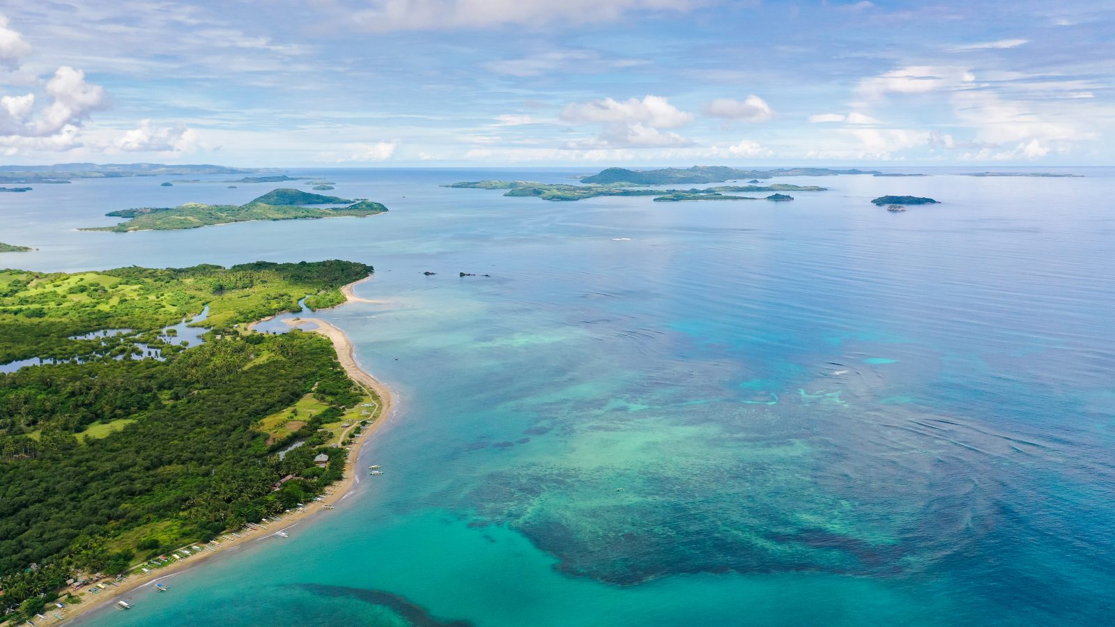 Malay archipelago with reefs and islands. Seascape with islands in the early morning, aerial drone. Beautiful landscape on the island of Luzon. Caramoan Islands, Philippines.