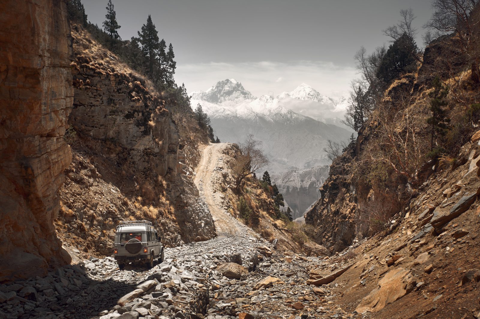 Off-road vehicle goes an extreme mountain path during an expedition to Himalayas