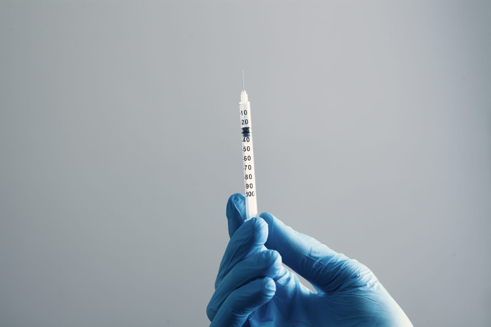 a doctor holding a syringe ready to give a vaccine injection