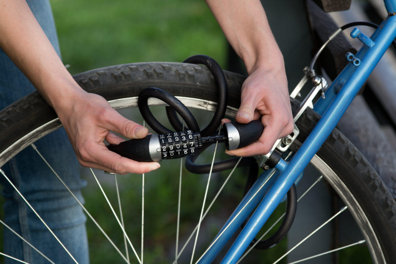 Woman locking bicycle with combination lock