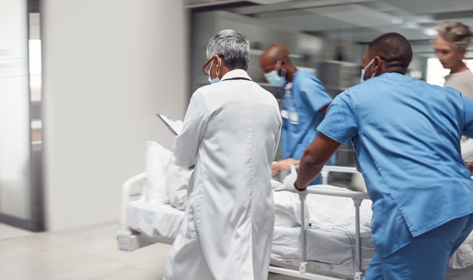 Busy, healthcare and doctors rush with patient, surgery and ready for procedure in hospital. Fast team, medical professional and staff with emergency, accident and health with wellness and nurses
