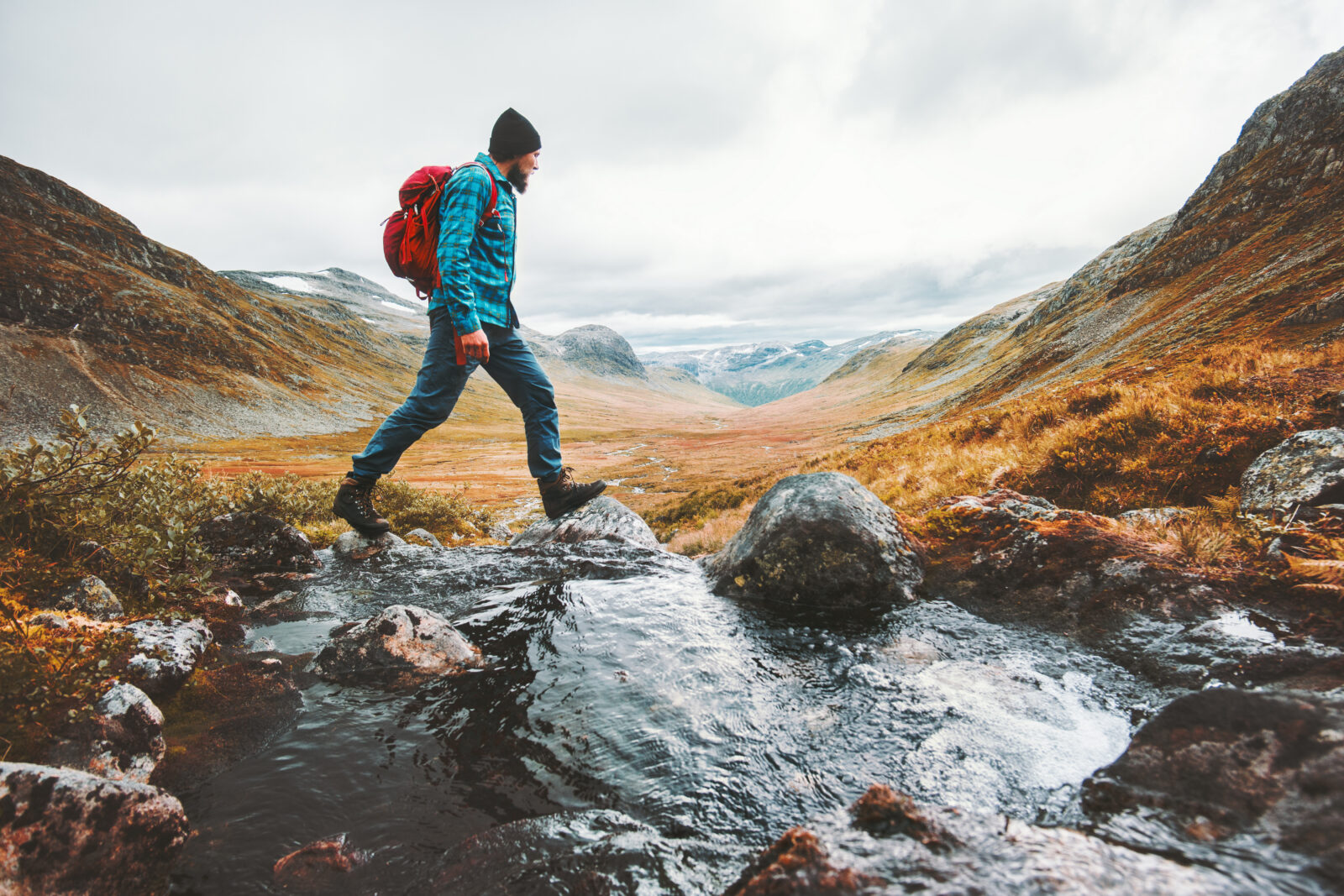 Man solo traveling backpacker hiking in scandinavian mountains active healthy lifestyle adventure journey vacations